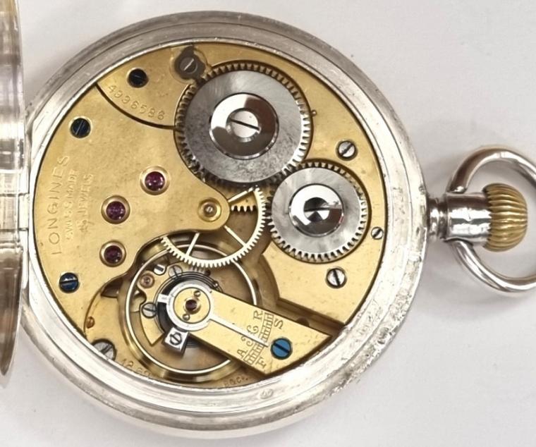 Longines pocket watch with top wind and time change in a silver case with London import hallmark for c1927. Signed white enamel dial with black Arabic hours and gilt hands with subsidiary seconds dial at 6 o/clock. Swiss signed 15 jewel jewelled lever movement with split bi-metallic balance and overcoil hairspring and numbered 4996586 with that number also repeated on the 'AB' case back.
