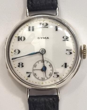 Swiss Cyma Tavannes Officers Style manual wind wrist watch in a silver case with London import hallmark c1923 on a black leather strap with gilt buckle. Signed white enamel dial with black numeric hours and blued steel hands with subsidiary seconds dial at 6 o/c. Swiss signed jewelled lever movement with overcoil hairspring with case back numbered 3305903 8867.