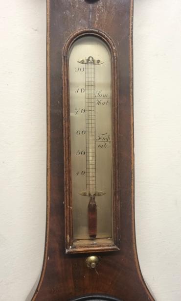 English C19th mahogany veneer cased mercury wheel barometer with hygrometer and alcohol Fahrenheit thermometer. Swan neck pediment with boxwood stringing throughout the lower casework. Circular brass bezel with convex glass over a silvered dial engraved with black inches of mercury pressure index and a blued steel pressure indicating hand with a gilt history marker. The alcohol spirit level indicator at the case bottom signed for 'P.Mantova' of 'Luton'. Height - 38" and width - 10.5".