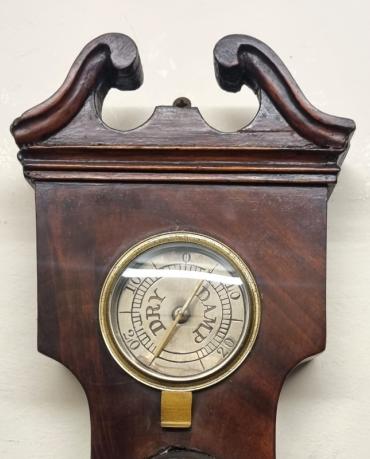 English mid C19th flame mahogany cased mercury wheel barometer with hygrometer and alcohol Fahrenheit thermometer. Swan neck pediment with moulding and plain lower casework with alcohol spirit level indicator at the case bottom. Circular brass bezel with convex glass over a silvered dial signed 'D.Fagioli & Son, Clerkenwell' and engraved with a black inches of mercury pressure index with a blued steel pressure indicating hand and gilt history marker. Height - 37" and width - 10.5".