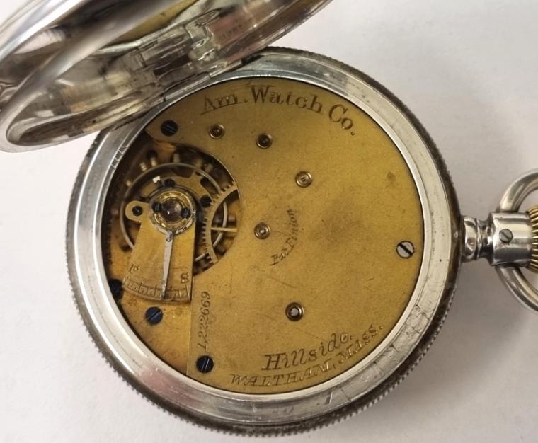 American Waltham 'Hillside' half hunter pocket watch in a silver case with top wind and rocking bar time change hallmarked for Chester c1877. Coin edge case with blue enamelled Roman hours on the outer and internal white enamel dial with black Roman hours and red outer minutes track with blued steel hands and subsidiary seconds dial at 6 o/c. Signed American Watch Company three quarter plate jewelled lever movement with split bi-metallic balance and numbered 1222669 with 'AB' case back numbered 30167. Case diameter 49.5mm.