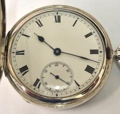 English Errington Watch Company full hunter pocket watch in a silver case hallmarked for London c1909. Top wind and time change with plain outer case over a white enamel dial with black Roman hours and blued steel hands with a subsidiary seconds dial at 6 o/c. English three quarter plate jewelled lever movement with split bi-metallic balance and overcoil hairspring and numbered 75619.