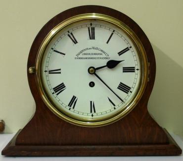 Good quality stained oak cased 8 day fusee timepiece, by Parkinson and W. & B. Cowan Ltd. White enamel dial with black roman hour markers and black steel hands, with flat glass and brass bezel surround.