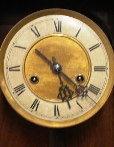 German 8 day gong striking wall clock circa 1900, spring driven pendulum movement housed in an oak and pine case with decorative turned finials and side columns together with applied swags and surmounted by an eagle. Ivory and brass coloured dial with black roman hour markers and black steel hands, and an enamel pendulum regulation plate at the case bottom.