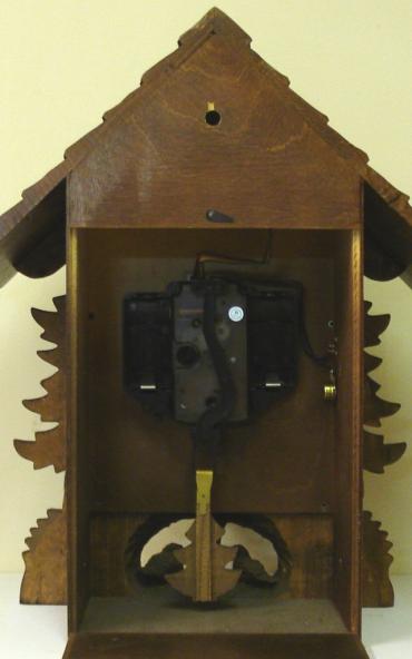New quartz mantel / wall cuckoo clock by Harzer. Pine wood case with stylised pine tree decoration and nesting bird motif. Traditional carved light coloured wood chapter ring with roman hours and matching wooden hands. Visible pendulum and carved light wood cuckoo bird display on the hour