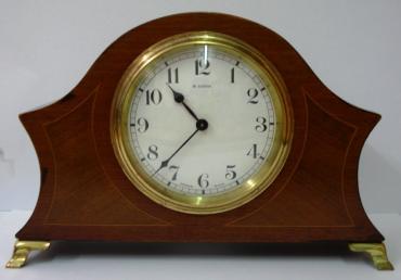 French 8 day mantel clock timepiece circa 1920 by Bayard, with boxwood inlay and marquetry panels on gilt brass bracket feet. Gilt brass bezel with convex glass over white enamel dial with black arabic hours and blued steel hands. Brass drum movement numbered #12889 with the Bayard back stamp, and inscribed '8 Days, Lever Movement, Made in France', '2 Jewels'.