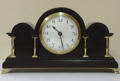 French 8 day mantel clock timepiece in an impressive triple arched dark mahogany case with gilt brass columns and bracket feet. Gilt brass bezel with convex glass over a white enamel dial with black arabic hours and black steel hands. Brass drum case movement maker unknown stamped 'France' with a good quality replacement lever escapement platform and a captive winding key.  Dimensions: Height - 11", width - 6", depth - 3.5".