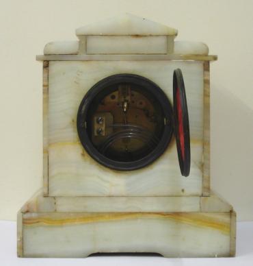 French 8 day white marble cased mantel clock circa 1890. Architectural square case with decorative applied ormolu mouldings and gilt circular bezel with flat chamfered glass over an ivory enamel chapter ring with silvered and gilt fretwork centre. Black gothic hours and ornate blued steel hands and slow / fast adjuster at 12 o/c. Good quality pendulum regulated, spring driven, gong striking French brass drum movement with an 'AD Mougin' 'Deux Medailles' touch mark and numbered #44.