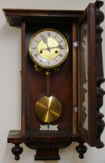 Clock for sale for restoration:- Vienna Regulator style stained pine cased gong striking wall clock by H.A.C. Flat top pediment, full length door with turned side columns, original glass over white dial with black roman hours, ornate blued steel hands. Standard brass spring driven pendulum regulated 8 day movement circa 1900. Back plate displays the H.A.C. crossed arrows mark. Lacks crest and some finials.
