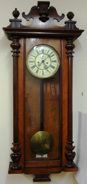 Clock for sale for restoration:- Vienna Regulator style mahogany and walnut cased gong striking wall clock by the Regulatorfabrik Germania Co. Crested pediment full length door with turned side columns, original glass over white enamel dial with black roman hours, ornate blued steel hands and subsidiary seconds dial. Good quality brass 'A' frame weight driven pendulum regulated 8 day movement circa 1880. Back plate displays the Regulatorfabrik Germania mark and is numbered #228746. Lacks some finials, weights and one weight pulley.
