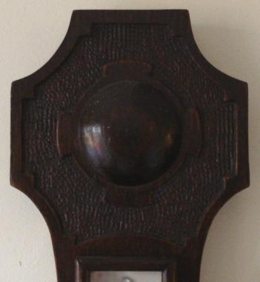 British made oak cased aneroid barometer with decorative Celtic cross chip carving. Circular chromed bezel over a silvered dial with black painted inches of mercury index and a separate mercury Fahrenheit and Centigrade thermometer.