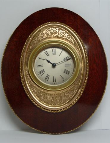 Late Victorian 8 day Straddle clock marked 'Harris, Queen's Square, Bath'. Silvered dial with black roman numerals and blued steel hands within an ornate gilded and engraved mask and  a mahogany frame.