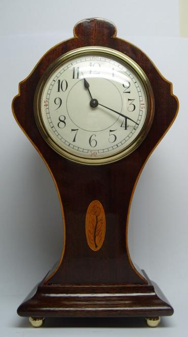 French 8 day mantel clock plain white enamelled dial arabic hour markers housed in a mahogany case with boxwood stringing and delicate marquetry inlay. 
