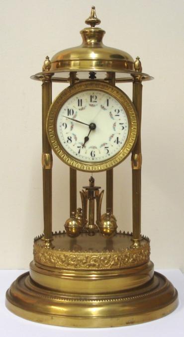 German 400 day Anniversary time piece circa 1920, maker unknown. Impressive brass dome over six  fluted support columns to ornate stepped brass base, with supported circular dial and movement. Gilt sunburst bezel with decorative enamel dial with floral swags and black arabic hours and matching hands. Standard 'anniversary' going movement with suspended oscillating slow / fast adjustable pendulum.