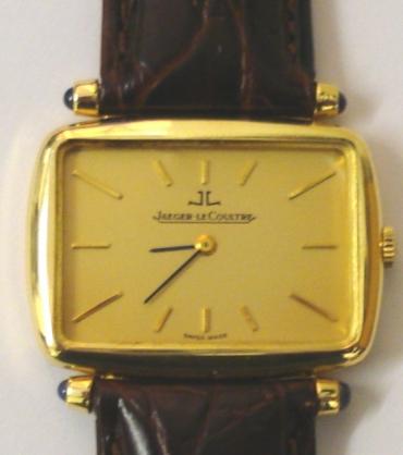 Swiss Jaegar LeCoultre manual wind wrist watch in a 18ct gold case on a brown leather strap with gilt buckle. Gold coloured dial with gilt baton hour markers and black and gilt hands. Signed jewelled lever movement with case numbered #4459 21 and #1350038 with London import hallmark for 1972.