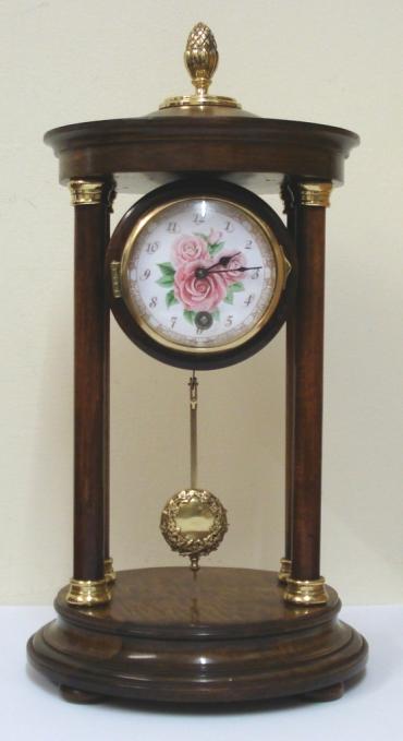German 8 day Portico time piece by the H.A.C. clock company of Wurttemberg circa 1900. Impressive brass finial topped dark stained wooden casework with turned support pillars and brass end pieces on a circular base with bun feet. Gilt brass bezel with convex glass over a floral decorated dial with arabic hours and black hands. Unmarked drum shaped brass spring driven pendulum regulated movement.  Dimensions: Height - 13", Width - 6.5", Depth - 6.5".
