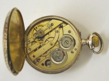 Ornate silver cased pocket watch with top wind and rocking bar time change. White enamel dial with black minute track and Roman hours with blued steel hands and subsidiary seconds dial. Swiss remontoir cylinder 6 jewel movement in a highly decorated case stamped 0.800 with ecclesiastical scene on outer case and numbered #587-17.
