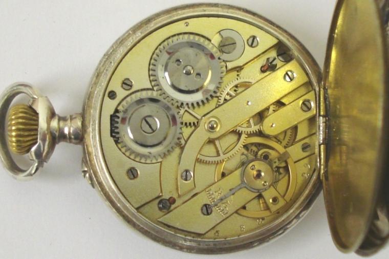 Ornate silver cased pocket watch with top wind and rocking bar time change. White enamel dial with black minute track and Roman hours with blued steel hands and subsidiary seconds dial. Swiss remontoir cylinder 6 jewel movement in a highly decorated case stamped 0.800 with ecclesiastical scene on outer case and numbered #587-17.