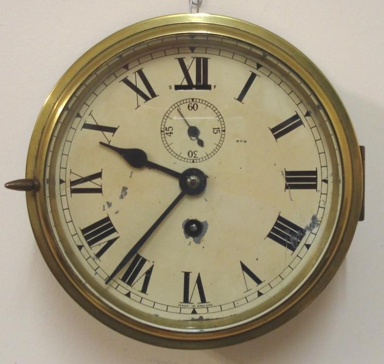 English heavy brass 8 day ship's clock timepiece c1940. Thick flat glass over a distressed ivory painted dial with black Roman hours and minute track and black steel hands with subsidiary seconds dial and slow / fast control at 12 o/c.  Dimensions - Height and width 7.25" and depth 3".
