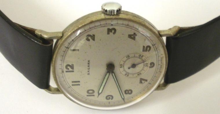 Swiss Sagara manual wind wrist watch on a black leather strap with silver buckle. Base metal case with stainless steel back numbered #316312 with silvered dial. Arabic hour markers with black luminous insert steel hands and subsidiary seconds dial. Swiss 15 jewel jewelled lever movement c1960.