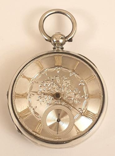English silver cased key wound fusee pocket watch with London hallmark for circa 1855. Silver engine turned and floral engraved dial with gilt Roman hours and matching Breguet style hands with subsidiary seconds dial at 6 o/c. Decoratively engraved cock piece with diamond end stone and unsigned back plate numbered #9410 with a further three wheels jewelled.