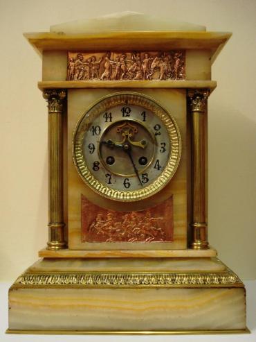 French 8 day gong striking, marble cased clock garniture, with Brocot style visible escapement. The movement by L.Marti et Cie with a 'Medaille de Bronze' backstamp is numbered 48 and is circa 1890. It is housed in an architectural style two colour marble case and is accompanied by two marble and brass side pieces surmounted by gilded urns. All three pieces display greek neo clcassical copper plaques and ornate gilded brass fluted columns with acanthus leaf plinths. 