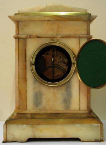 French 8 day gong striking, marble cased clock garniture, with Brocot style visible escapement. The movement by L.Marti et Cie with a 'Medaille de Bronze' backstamp is numbered 48 and is circa 1890. It is housed in an architectural style two colour marble case and is accompanied by two marble and brass side pieces surmounted by gilded urns. All three pieces display greek neo clcassical copper plaques and ornate gilded brass fluted columns with acanthus leaf plinths. 