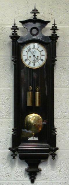 Ebonised cased 8 day, key wound, weight driven, gong striking, Vienna style Regulator movement, dating from c1880. Casework incorporates turned wood finials and full length glazed door. White enamel dial with black roman hours and ornate steel hands and subsidiary seconds dial.  Dimensions - Height 51", Width 14", Depth 6".