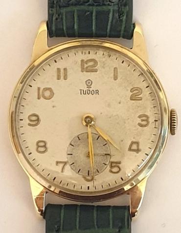 Rolex Tudor manual wind wrist watch in a 9ct gold case with dark green leather strap and gilt buckle. Silvered dial with gilt Arabic hours and polished gilt hands with a subsidiary seconds dial at 6 o/c. Signed Tudor ETA calibre 1260 15 jewel movement in a Dennison 9ct gold case with a Birmingham hallmark for 1956, model 12856 and numbered 752397.