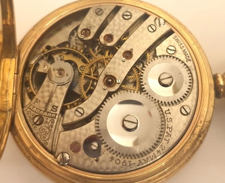Swiss half hunter pocket watch in a 9ct gold Dennison case hallmarked for Birmingham c1921 with top wind and time change. External black Roman chapter ring on the case outer, internal white enamel dial with black Roman hours and blued steel hands and a subsidiary seconds dial at 6 o/c. Swiss jewelled lever movement with overcoil hairspring and split bi-metallic balance jewelled to the centre, with gold case numbered 223851 and complete with plush lined retail case.