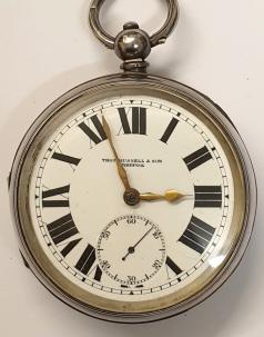 Large English silver cased pocket watch by William Ehrhardt of Birmingham, retailed by Thos Russell & Son, Liverpool, the 'WE' made case hallmarked for Birmingham 1919, and numbered 755102. Key wind and time change with retail signed white enamel dial with black Roman hours and gilt hands and subsidiary seconds dial. Plain back plate also numbered 755102 with plain cock piece, going barrel movement with bi-metallic jewelled balance.