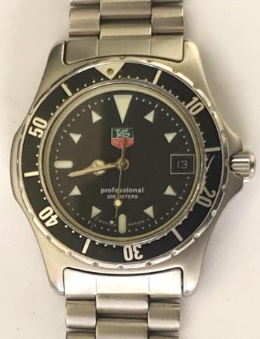Swiss Tag Heuer Professional 2000 quartz wrist watch in a stainless steel case with integral bracelet circa 1993. Black rotating safety bezel over a black dial with white luminous dart hour markers and luminous insert Tag hands together with a central seconds hand and date display at 3 o/c. Screw on case back water resistant to 200 metres and complete with original retail box and papers.
