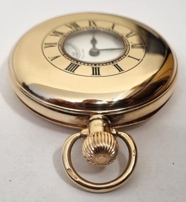 Swiss Zenith 9ct gold half hunter pocket watch in a Dennison case hallmarked for Birmingham c1920 with top wind and time change. Black Roman hours on the outer case and internal signed white enamel dial with black hours and blued steel hands with a subsidiary seconds dial at 6 o/c. High quality signed Swiss 17 jewel lever movement numbered 2536723 with micro regulator system, bi-metallic balance and overcoil hairspring. The English Dennison case is numbered 204418 and the watch is complete with the original retailer's plush lined case.