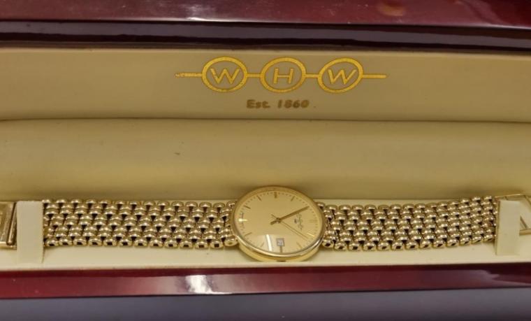 Modern Gents 9ct Gold quartz wrist watch by WHW circa 2005 and complete with original box and papers. 9ct gold case and integral bracelet with gilt dial and polished baton hour markers and matching hands together with a central seconds hand and date display at 3 o/c. Total watch weight - 55 grams.