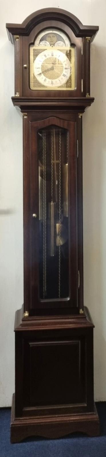 Mahogany cased 8 day, weight driven, pendulum regulated Westminster chime longcase / grandmother clock. Round topped hood with fluted columns and break arch dial with moon phase and applied brass spandrels around the silvered chapter ring. Black Roman hours and gothic style black hands with a Chime / Silent selection lever at 3 o'clock. Fluted columns repeated to the lower case with glazed door displaying the brass weights and pendulum. Case dimensions - Height 61", Width 14.5", Depth 9.5".